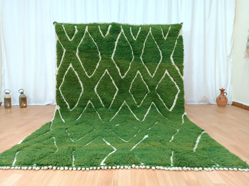 May include: A green and white Moroccan rug with a diamond pattern. The rug has a fringe border.