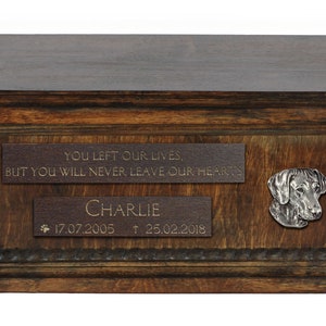 May include: A wooden pet urn with a brass plaque that reads "YOU LEFT OUR LIVES, BUT YOU WILL NEVER LEAVE OUR HEARTS CHARLIE 17.07.2005 † 25.02.2018". A brass dog head is attached to the urn.