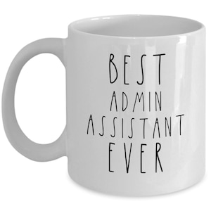 Puede incluir: Taza de café de cerámica blanca con texto negro que dice "BEST ADMIN ASSISTANT EVER".