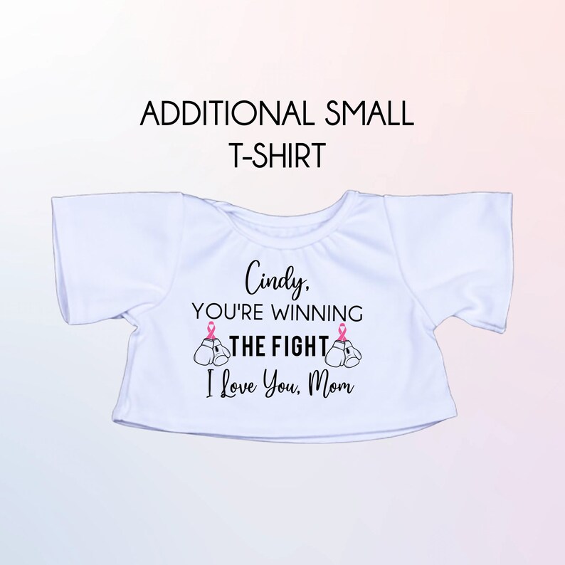 May include: White t-shirt with a pink ribbon design and the text "Cindy, You're Winning The Fight I Love You, Mom".