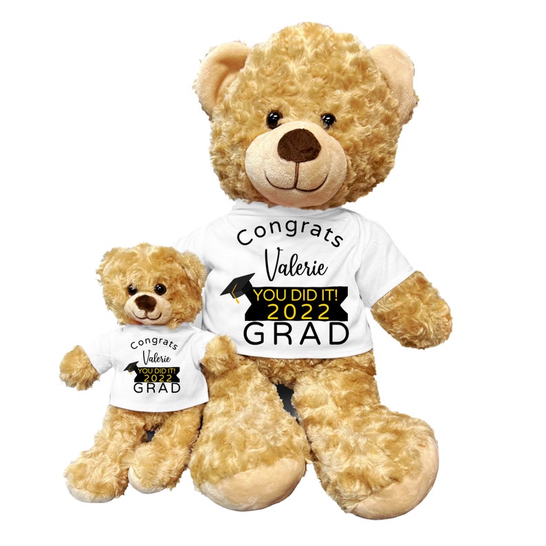 Puede incluir: Dos osos de peluche marrones que llevan camisetas blancas con texto negro que dice "Congrats Valerie You Did It! 2022 Grad". El oso m&aacute;s grande est&aacute; sentado con las piernas extendidas. El oso m&aacute;s peque&ntilde;o est&aacute; sentado con las piernas metidas debajo de su cuerpo.