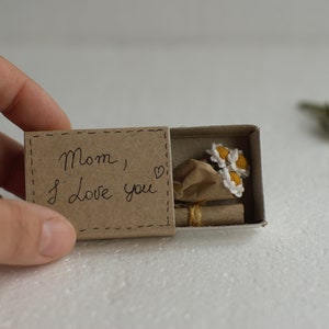 Pudełko niespodzianek z drobnymi szydełkowymi kwiatami, miniaturowe kwiaty rumianku: drobne, urocze prezenty na Dzień Matki