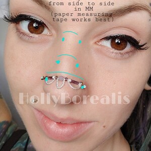 May include: Close-up of a person's face with a nose ring. The nose ring features a silver chain design with purple and white beads. Text in the image reads: "measure your holes from side to side in MM (paper measuring tape works best)." The watermark "HollyBorealis" is visible.