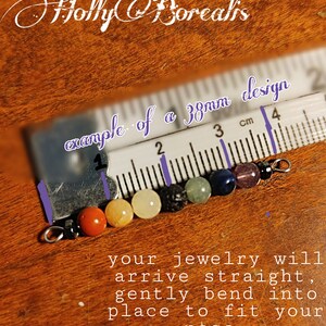 May include: A close-up of a jewelry piece with colorful beads, including orange, yellow, black, green, blue, purple, and clear beads. The text "example of a 38mm design" is visible. The text "your jewelry will arrive straight, gently bend into place to fit your nose" is also visible.