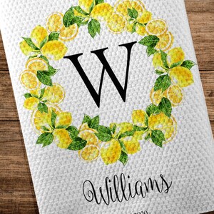 May include: White kitchen towel with a lemon wreath design. The wreath surrounds a large black letter "W". The word "Williams" is written in cursive below the letter, with "EST 2020" underneath.