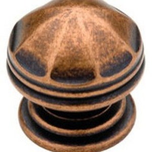 May include: A bronze cabinet knob with a textured, domed top and a layered base. The knob has a dark, aged finish with visible wear, suggesting an antique or vintage style. The knob is designed for furniture hardware.