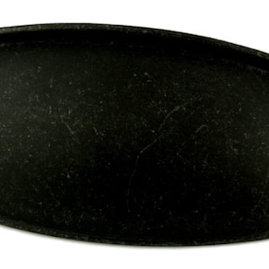 May include: Black oval cabinet pull with a slightly raised edge. The pull has a distressed finish.