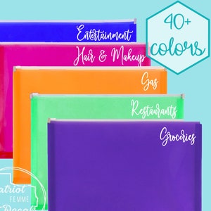 May include: Five clear plastic zippered pouches with white text labels. The labels read "Entertainment", "Hair & Makeup", "Gas", "Restaurants", and "Groceries". The pouches are stacked on top of each other. The text "40+ colors" is in a hexagon shape in the top right corner of the image.