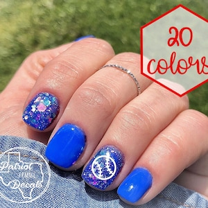 May include: Close-up of a hand with blue nail polish and glitter nail polish. One nail has a white baseball design. The text "20 colors" is in a red hexagon.