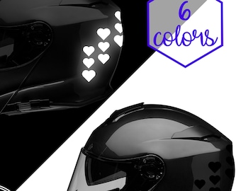 Könnte beinhalten: Zwei schwarze Motorradhelme mit einem Design aus weißen Herzen auf dem einen Helm und schwarzen Herzen auf dem anderen. Die Helme werden vor einem weißen und schwarzen Hintergrund gezeigt. Der Text "Patriot Femme Decals" wird in einem Kreis mit einer Umrandung von Texas angezeigt.