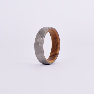 Anello in titanio battuto esterno e legno di olivo interno.
Anello personalizzabile /
Anello matrimonio /
fede nuziale.
External wrought titanium ring and internal olive wood ring.
Customizable ring /
Wedding ring /
wedding ring