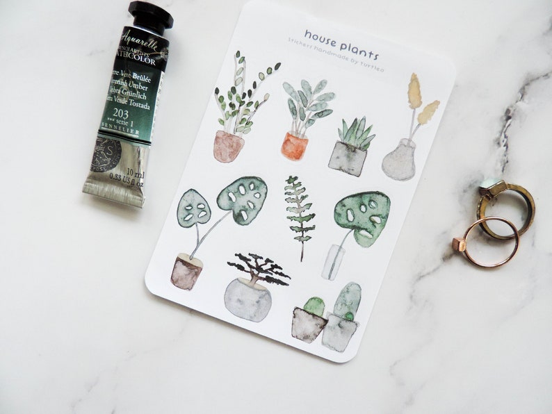 May include: A sheet of stickers featuring watercolor illustrations of house plants in pots. The stickers are labeled "house plants" and "stickers handmade by tuttled".