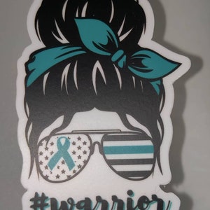Puede incluir: Una pegatina en blanco y negro con la cara de una mujer, una cinta turquesa y el texto "#warrior". La mujer tiene un mo&ntilde;o desordenado con una cinta turquesa y gafas de sol con una cinta turquesa y un patr&oacute;n de bandera estadounidense.
