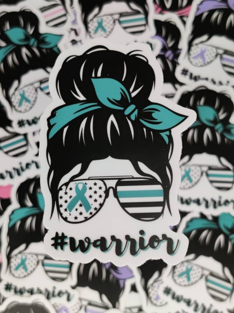 Puede incluir: Una pegatina con una imagen de dibujos animados de una mujer con un mo&ntilde;o desordenado, que lleva gafas de sol con una cinta turquesa y una cinta turquesa atada alrededor de su mo&ntilde;o. Las gafas de sol tienen una fina l&iacute;nea azul y estrellas en las lentes. El texto '#warrior' est&aacute; debajo de la imagen.