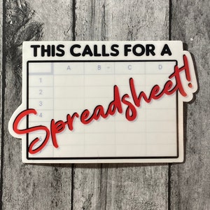 Può includere: Un adesivo bianco con un design a griglia di foglio di calcolo e la scritta "THIS CALLS FOR A Spreadsheet!" in nero e rosso. L'adesivo ha un bordo nero ed è su una superficie di legno grigio.