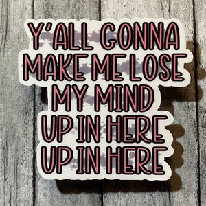 Op de afbeelding: Een witte sticker met de tekst "Y'all Gonna Make Me Lose My Mind Up In Here Up In Here" in roze en zwarte letters. De achtergrond heeft een aquarelachtig ontwerp in paarse en grijze tinten.