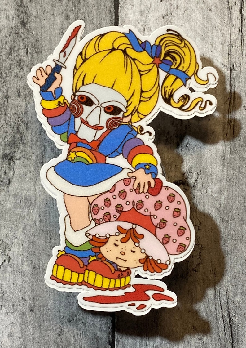 May include: A sticker featuring a cartoon character with a rainbow dress and a scary mask holding a knife over another cartoon character with a strawberry dress.
