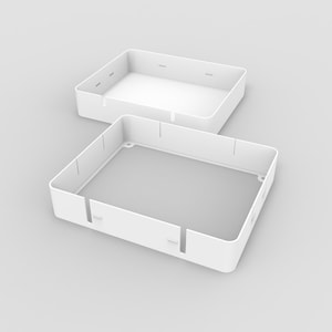 May include: Two white, square, open-top boxes, one nested inside the other. The boxes have rounded corners and evenly spaced slots along the sides. The boxes are on a light gray background.