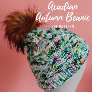 May include: A colorful, hand-knitted beanie with a large, fluffy brown pom-pom. The hat features a mix of white, green, blue, and purple yarn. Text on the image reads "Acadian Autumn Beanie PDF Pattern."
