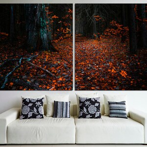 May include: A split canvas print of a dark forest path covered in fallen orange leaves. The path leads into the woods, with tall trees on either side. The image is dark and moody, with a sense of mystery.