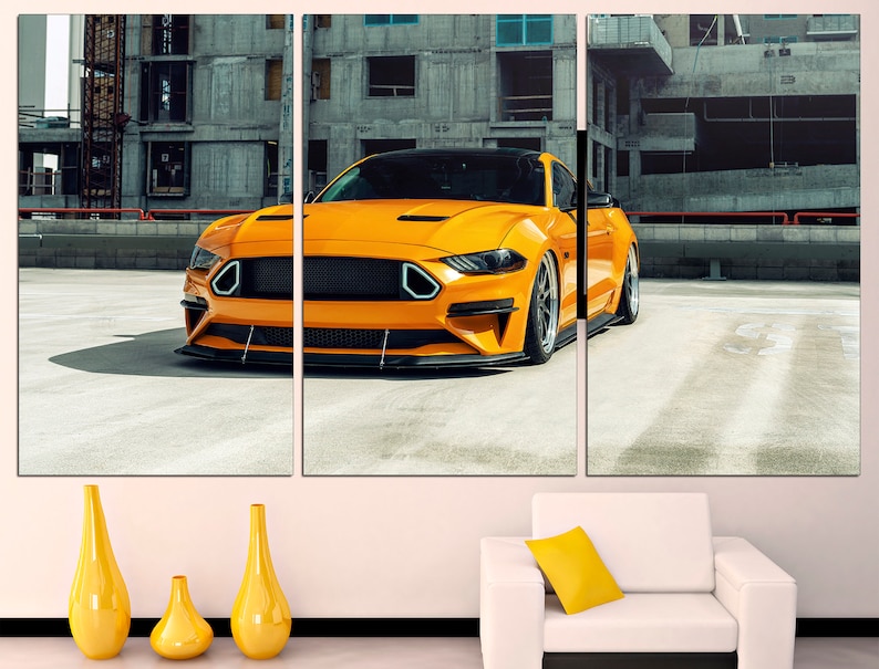 May include: A bright yellow sports car parked in a concrete urban setting. The car has a black grille and black wheels. The car is in focus, while the background is blurred.