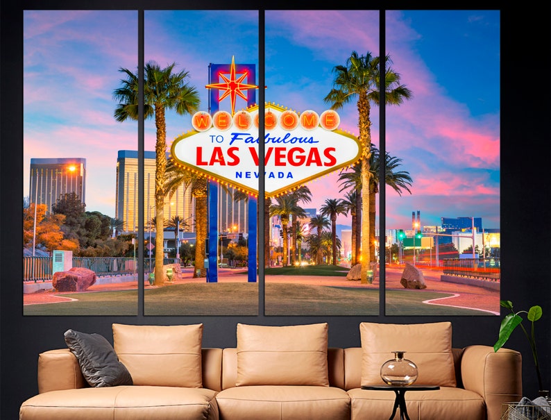 May include: A multi-panel canvas print featuring the iconic "Welcome to Fabulous Las Vegas Nevada" sign at dusk. The sign is illuminated with warm lights, set against a backdrop of palm trees, buildings, and a colorful sky.