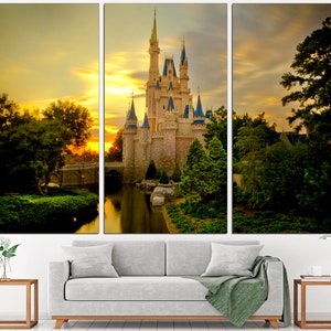 May include: A fairytale castle bathed in the golden light of sunset, surrounded by verdant trees and a reflective lake. The castle features multiple towers and spires, and the sky is a vibrant orange and yellow.