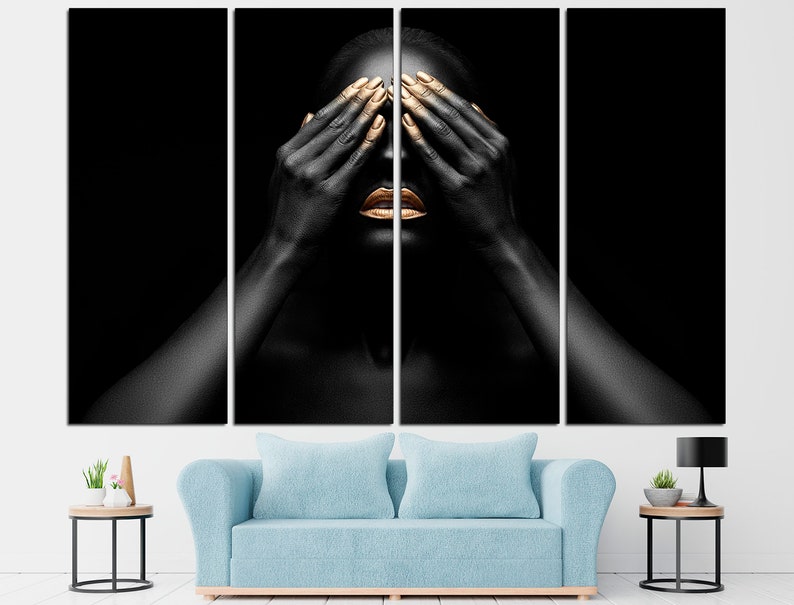 May include: A person with black skin and gold makeup covers their eyes with their hands. The background is black.