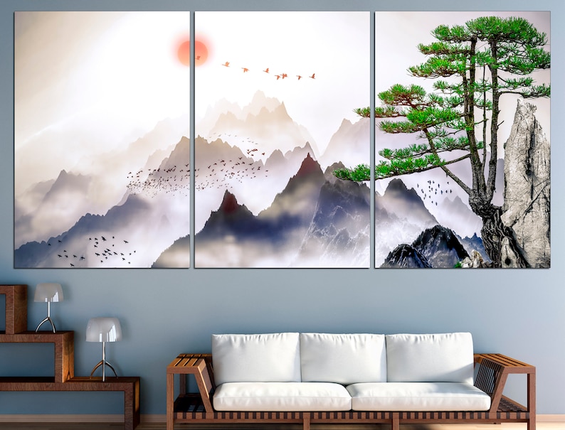 May include: A three-panel canvas print featuring a misty mountain landscape with a lone pine tree on a rocky cliff. The mountains are painted in shades of blue and gray, with a soft, ethereal glow. The pine tree is a vibrant green, with its branches reaching out towards the sky. The print is a beautiful and serene depiction of nature.