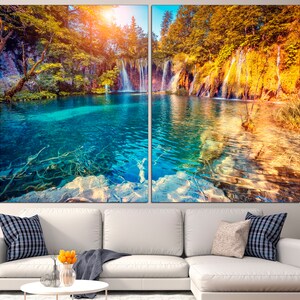 May include: A split canvas print of a waterfall cascading into a turquoise lake surrounded by lush green and yellow trees in an autumnal forest.