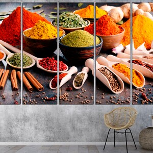 May include: A close-up of a variety of spices in bowls and spoons, including red pepper flakes, turmeric, cinnamon sticks, and coriander seeds. The spices are arranged on a wooden surface.