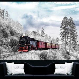 May include: A black and red steam train travels along a track through a snowy, black and white forest. The train has several red passenger cars. The sky is a pale blue with some clouds. The image is a print on a canvas.