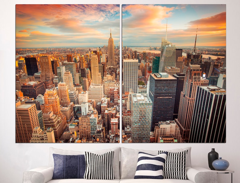 May include: A panoramic view of the New York City skyline at sunset, with tall skyscrapers and a golden sky.