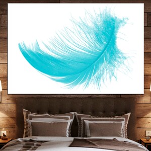 May include: A single, turquoise blue feather isolated on a white background. The feather is soft and delicate, with a slight curve to it.