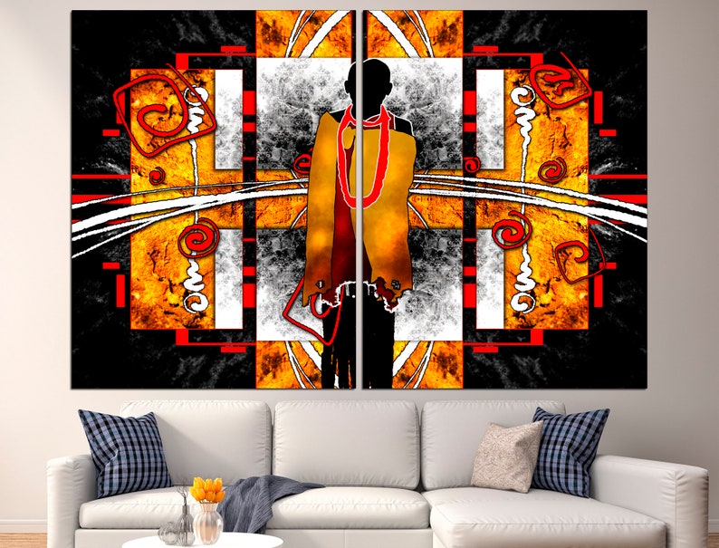 May include: Abstract wall art featuring a silhouetted figure draped in a yellow and red garment. The artwork has a geometric design with orange, black, white, and red elements. The piece is displayed above a white sofa with decorative pillows.