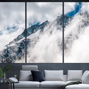 Puede incluir: Una vista panor&aacute;mica de un pico de monta&ntilde;a cubierto de nieve parcialmente oscurecido por nubes blancas. La monta&ntilde;a es de color gris oscuro con parches de nieve. El cielo es azul claro con nubes blancas.