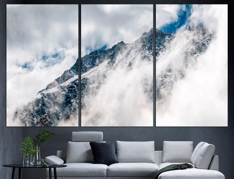 Puede incluir: Una vista panor&aacute;mica de un pico de monta&ntilde;a cubierto de nieve parcialmente oscurecido por nubes blancas. La monta&ntilde;a es de color gris oscuro con parches de nieve. El cielo es azul claro con nubes blancas.