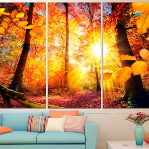 May include: A three-panel canvas print depicting a forest scene with vibrant autumn colors. The sun shines through the trees, casting golden rays of light on the ground. The leaves are a mix of red, orange, and yellow.