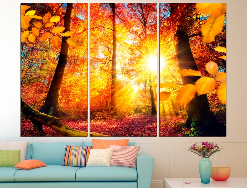 May include: A three-panel canvas print depicting a forest scene with vibrant autumn colors. The sun shines through the trees, casting golden rays of light on the ground. The leaves are a mix of red, orange, and yellow.