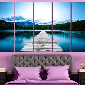 May include: A five-panel canvas print depicting a wooden dock extending into a still lake with a mountain range in the background. The lake is a vibrant blue, and the sky is a soft blue with white clouds. The dock is made of weathered wood planks.
