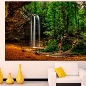 Peut inclure: Une grande toile imprim&eacute;e repr&eacute;sentant une cascade dans une for&ecirc;t luxuriante. L'eau tombe dans un bassin, entour&eacute;e d'arbres verts. La sc&egrave;ne se d&eacute;roule dans une alc&ocirc;ve rocheuse, avec une lumi&egrave;re chaude. Des vases jaunes sont au premier plan.
