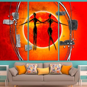 May include: Abstract art print featuring two stylized figures in black against a red and orange background with a large orange circle in the center.