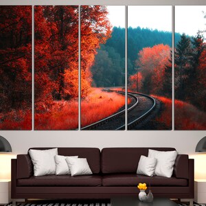 K&ouml;nnte beinhalten: Ein mehrteiliger Leinwanddruck mit einer malerischen Landschaft, in der sich ein Bahngleis durch einen Wald schl&auml;ngelt. Die B&auml;ume sind in Rot- und Oranget&ouml;nen gehalten und schaffen eine lebendige Herbstszene.