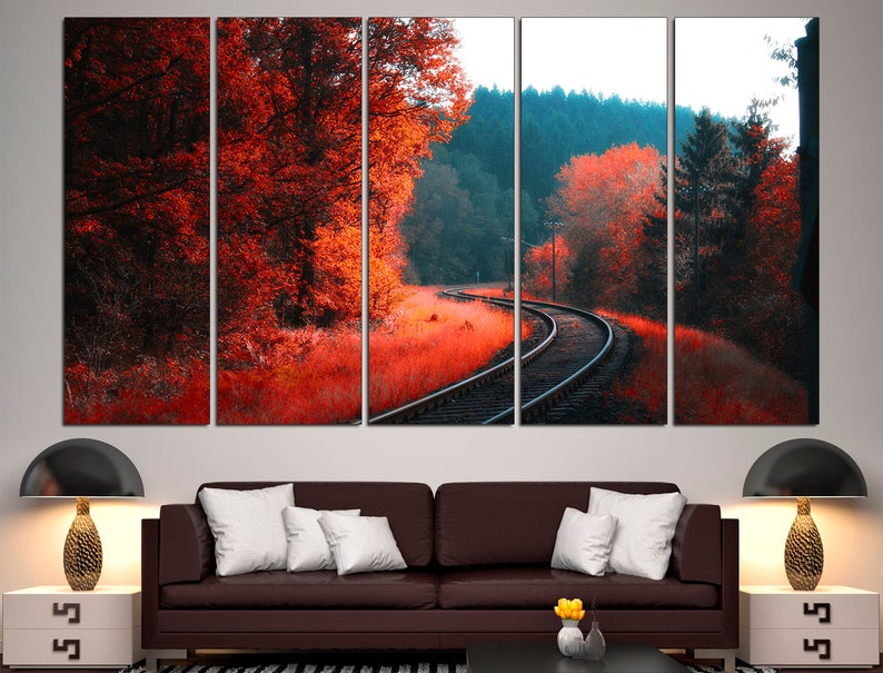 K&ouml;nnte beinhalten: Ein mehrteiliger Leinwanddruck mit einer malerischen Landschaft, in der sich ein Bahngleis durch einen Wald schl&auml;ngelt. Die B&auml;ume sind in Rot- und Oranget&ouml;nen gehalten und schaffen eine lebendige Herbstszene.