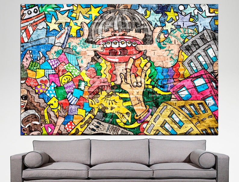 Puede incluir: Un mural de estilo graffiti colorido con un personaje de dibujos animados con una boca grande y dientes, rodeado de formas geom&eacute;tricas, estrellas y edificios. El mural est&aacute; pintado en colores brillantes, incluyendo rojo, amarillo, azul, verde y morado.