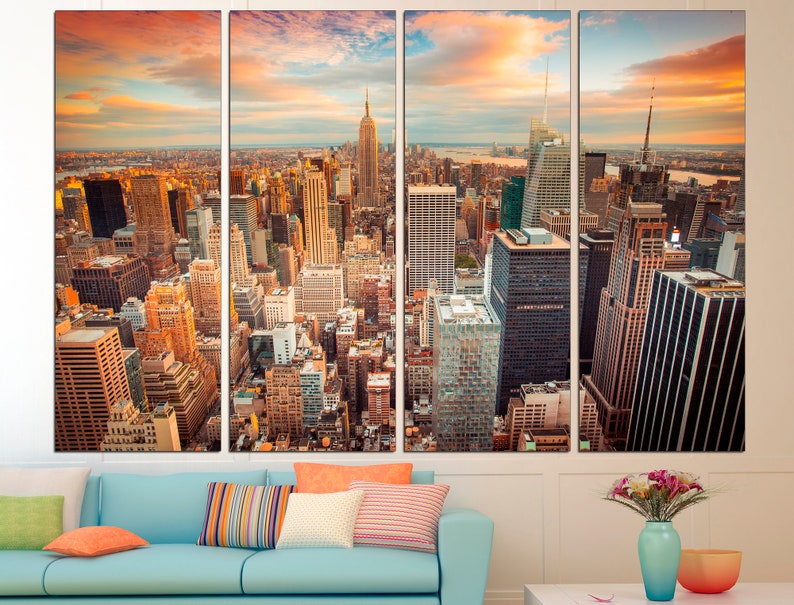 May include: A panoramic view of the New York City skyline at sunset, featuring the Empire State Building and other skyscrapers. The city is bathed in warm, golden light, with clouds casting long shadows across the buildings.