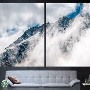 Puede incluir: Un pico de monta&ntilde;a nevado parcialmente oculto por nubes blancas contra un cielo azul.