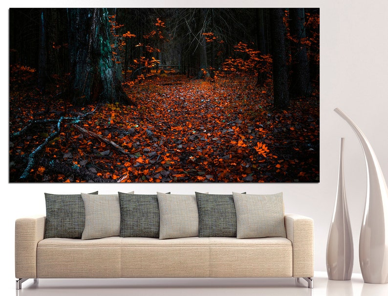 May include: A dark forest path lined with fallen orange leaves. The path leads into the distance, disappearing into the trees. The forest floor is covered in leaves, and the trees are tall and dark.