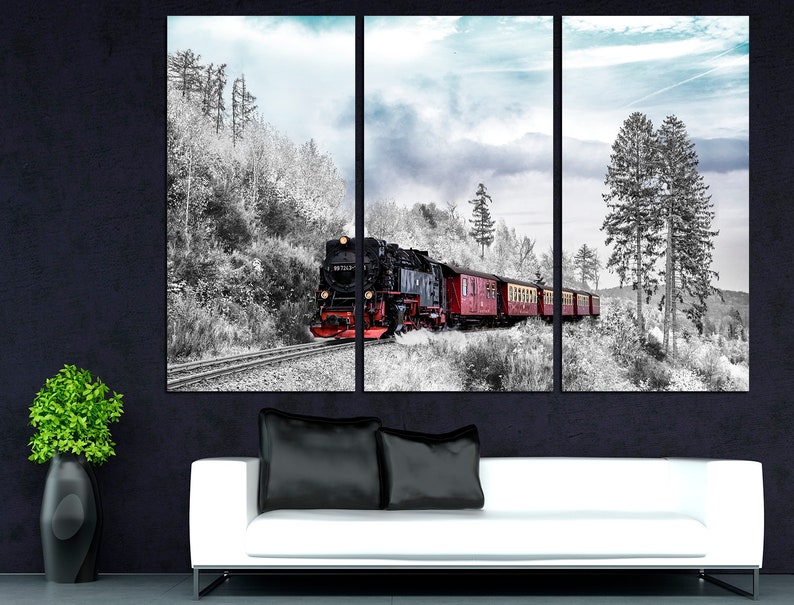 May include: A triptych canvas print featuring a vintage steam train traveling through a snowy landscape. The train is black and red, with red passenger cars. The surrounding forest is in black and white, with a touch of blue sky.