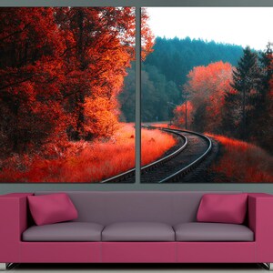K&ouml;nnte beinhalten: Ein zweiteiliger Leinwanddruck mit einer malerischen Landschaft, auf der sich ein Bahngleis durch einen Wald schl&auml;ngelt. Das linke Panel zeigt eine Nahaufnahme von roten und orangen B&auml;umen, w&auml;hrend das rechte Panel eine weitere Ansicht des Gleises mit einem Wald im Hintergrund zeigt.